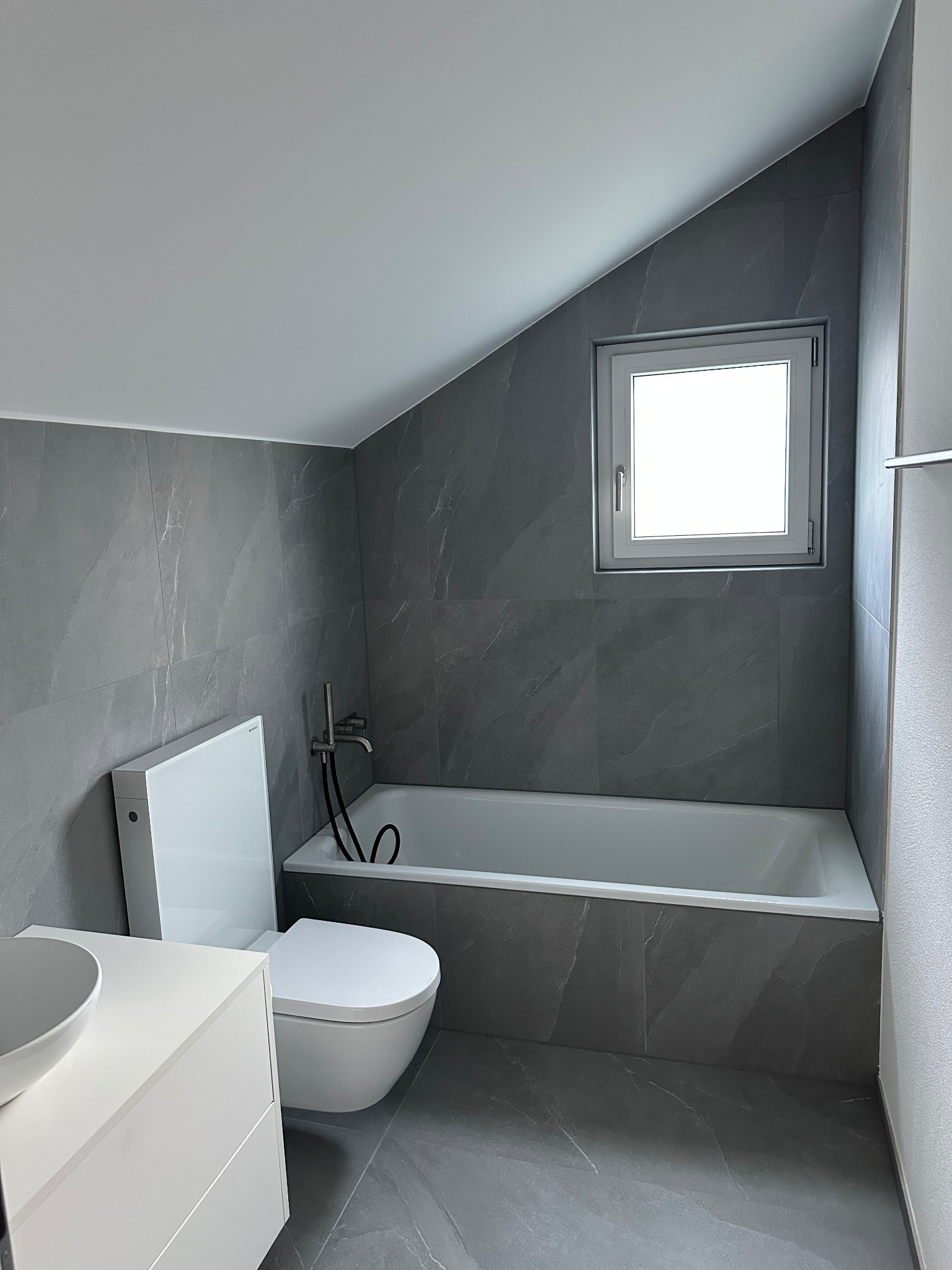 Badezimmer mit grauen Fliesen